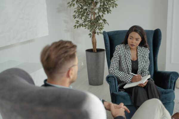 A therapist listens to a patient during a session, capturing a professional and empathetic environment.